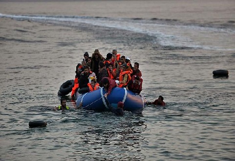 Refugees and migrants massed onto an inflatable boat reach Mytilene, northern island of Lesbos, after crossing the Aegean sea from Turkey on February 17, 2016. / AFP / ARIS MESSINIS (Photo credit should read ARIS MESSINIS/AFP/Getty Images)